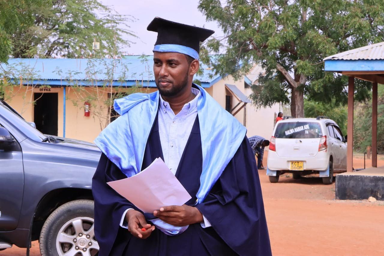 A graduate outside the college buildings